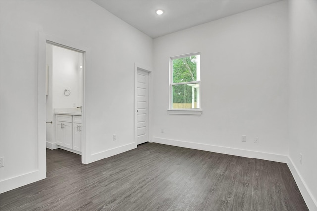 empty room with baseboards, recessed lighting, and dark wood-type flooring
