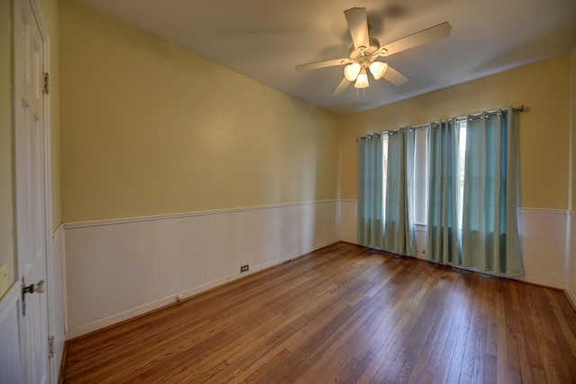 266 Monroe St, Giddings, TX 78942 - unfurnished room with wood-type flooring, a wainscoted wall, and a ceiling fan