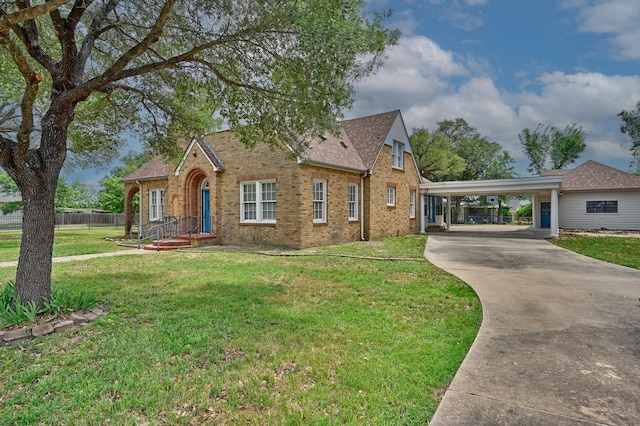 266 Monroe St, Giddings, TX 78942 - tudor home with brick siding, driveway, an attached carport, and roof with shingles