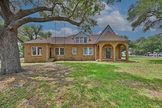 266 Monroe St, Giddings, TX 78942 - rear view of property with a lawn, brick siding, and a shingled roof