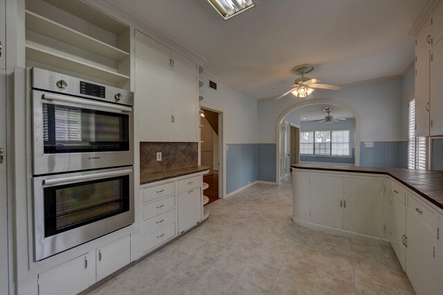 266 Monroe St, Giddings, TX 78942 - kitchen featuring double oven, dark countertops, a ceiling fan, decorative backsplash, and crown molding