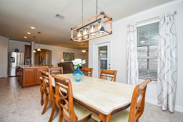 dining area featuring crown molding, light tile patterned flooring, and arched walkways
