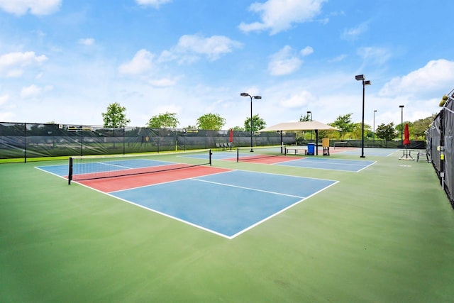 view of tennis court featuring fence and community basketball court