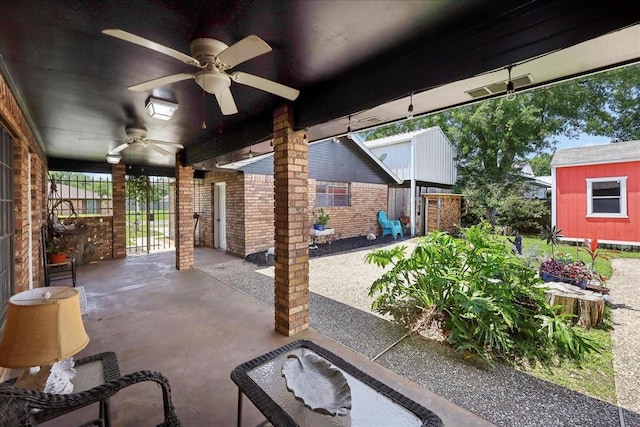view of patio with a storage shed, ceiling fan, and an outbuilding