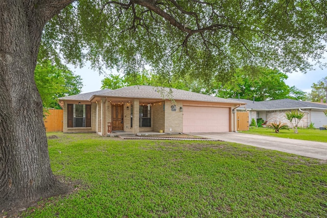 ranch-style house with a front yard, driveway, brick siding, an attached garage, and fence
