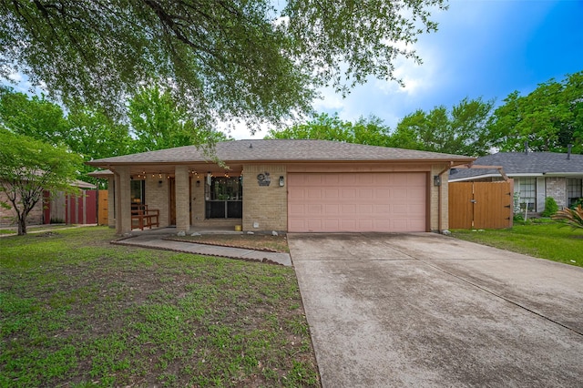 ranch-style house featuring concrete driveway, covered porch, fence, brick siding, and a garage