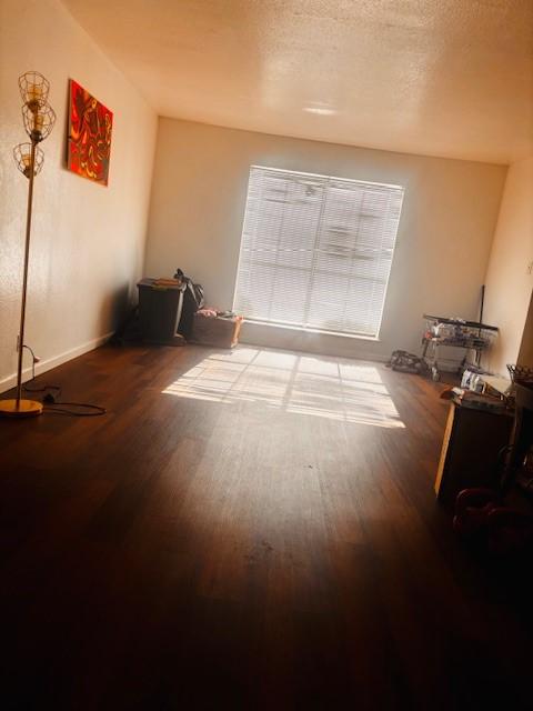 6200 W Tidwell Rd Unit 1701, Houston, TX 77092 - empty room featuring wood finished floors, a textured ceiling, and baseboards