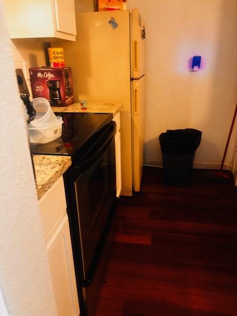 6200 W Tidwell Rd Unit 1701, Houston, TX 77092 - kitchen featuring black / electric stove, light countertops, dark wood finished floors, and white cabinetry