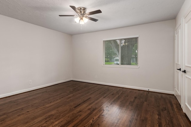 unfurnished room featuring a ceiling fan, dark wood-style floors, and baseboards