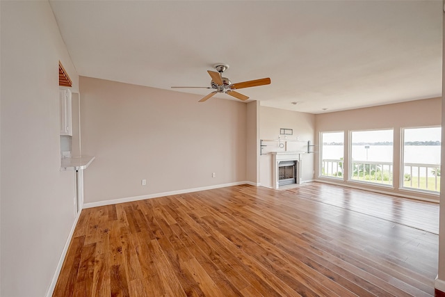 10 Mariner Village Dr, Pasadena, TX 77586 - unfurnished living room featuring baseboards, a ceiling fan, light wood-style floors, and a fireplace