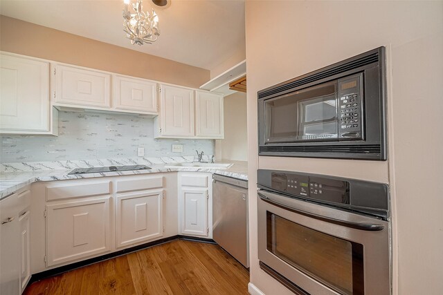 10 Mariner Village Dr, Pasadena, TX 77586 - kitchen featuring white cabinets, a sink, appliances with stainless steel finishes, wood finished floors, and backsplash