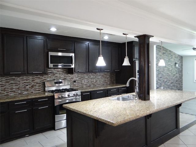 kitchen featuring light tile patterned flooring, a sink, stainless steel appliances, and a kitchen bar