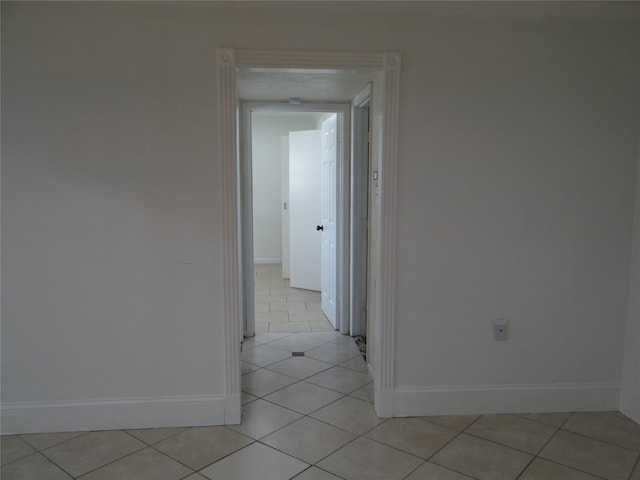 hallway with light tile patterned floors and baseboards