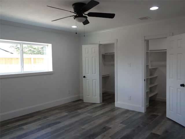 unfurnished bedroom featuring crown molding, baseboards, recessed lighting, dark wood-type flooring, and a spacious closet