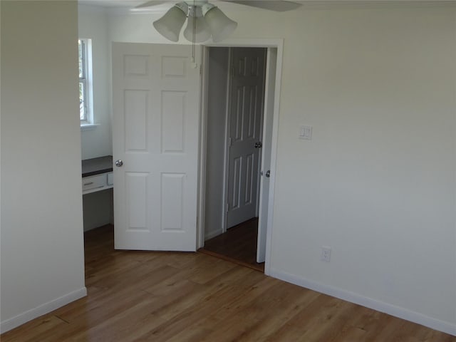 unfurnished bedroom featuring a ceiling fan, wood finished floors, and baseboards