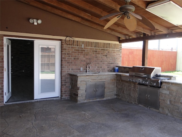 view of patio with fence, area for grilling, ceiling fan, and a sink