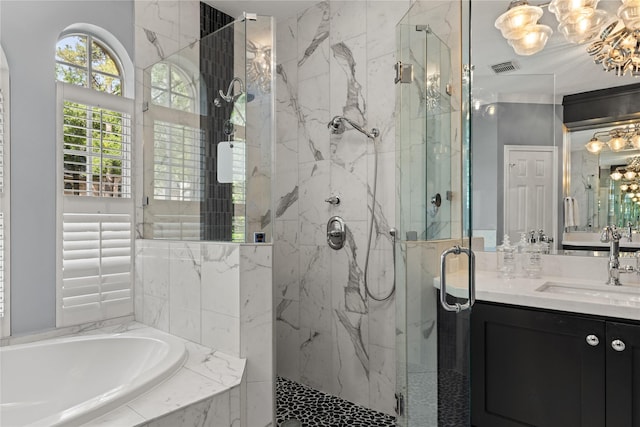 full bath with a notable chandelier, a marble finish shower, a garden tub, and vanity
