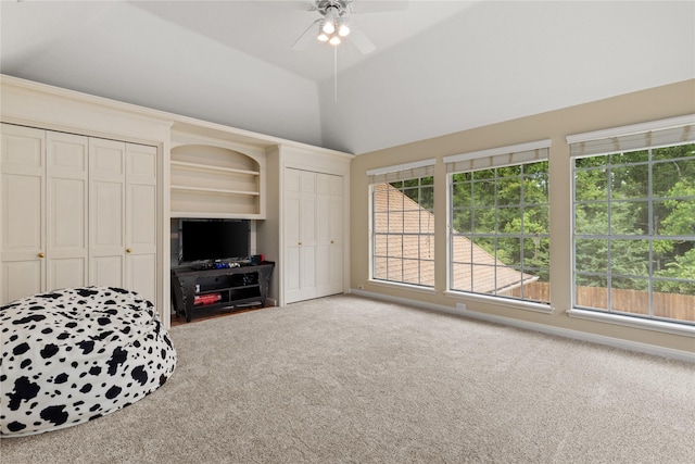 interior space with ceiling fan, carpet floors, and lofted ceiling
