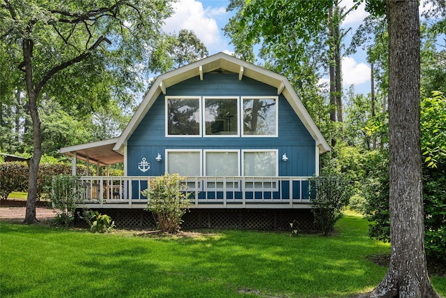 rear view of house featuring a lawn and a deck