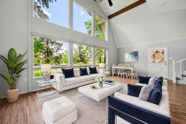 living area with wood finished floors, high vaulted ceiling, and beamed ceiling