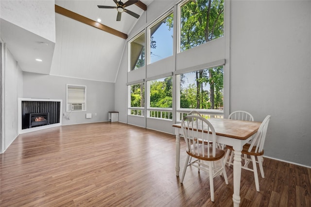 interior space featuring beamed ceiling, high vaulted ceiling, ceiling fan, cooling unit, and wood finished floors