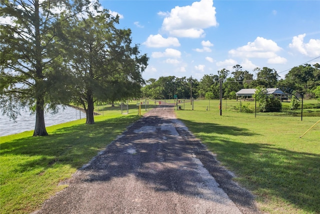 view of road with driveway and a water view