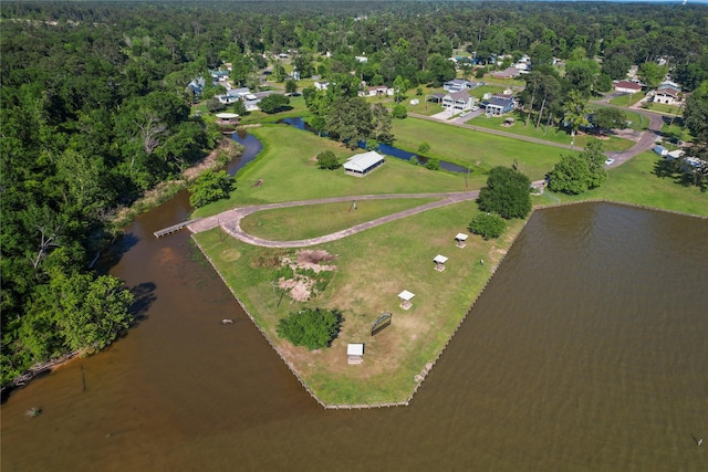 birds eye view of property featuring a water view and a wooded view