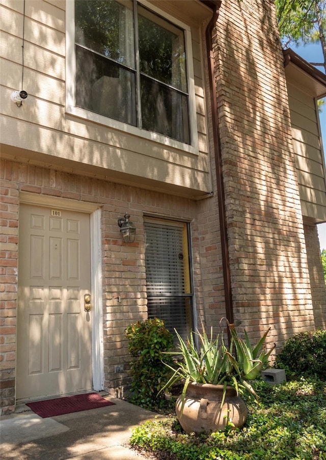 entrance to property featuring brick siding