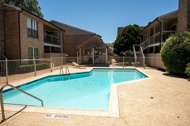 pool with fence, stairs, and a patio