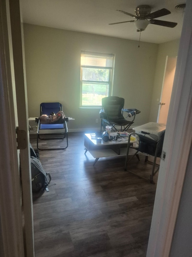 sitting room with baseboards, wood finished floors, and a ceiling fan