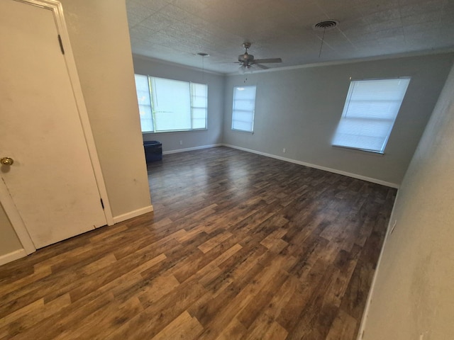 empty room with visible vents, ceiling fan, baseboards, and dark wood finished floors