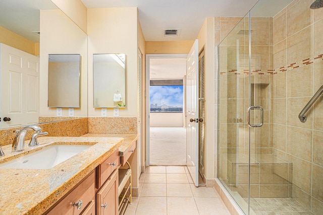 bathroom with tile patterned floors, visible vents, a stall shower, and vanity