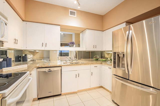 kitchen with a sink, white cabinetry, stainless steel appliances, and visible vents
