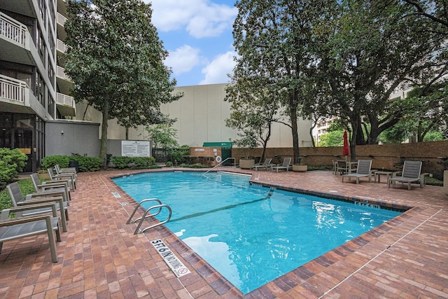 community pool featuring fence and a patio