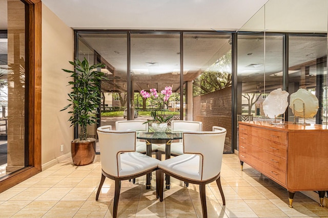 dining room with baseboards, light tile patterned floors, and a wall of windows
