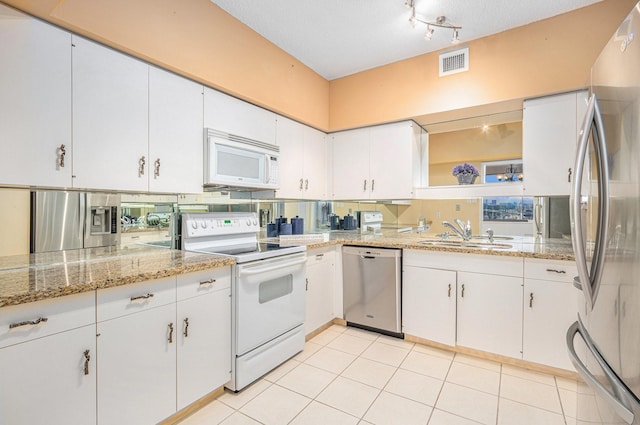 kitchen with white cabinetry, open shelves, a sink, visible vents, and stainless steel appliances