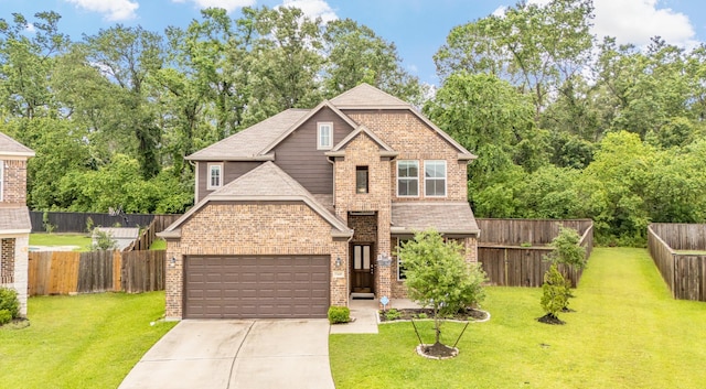 view of front of property with concrete driveway, a front yard, an attached garage, brick siding, and a fenced backyard