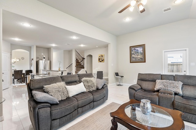 living room with light tile patterned floors, arched walkways, visible vents, and a ceiling fan