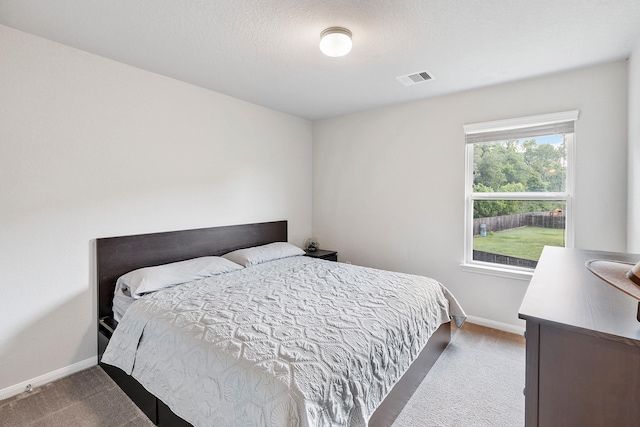 carpeted bedroom with baseboards and visible vents