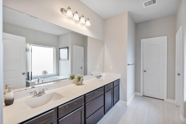 full bathroom with a sink, double vanity, visible vents, and baseboards