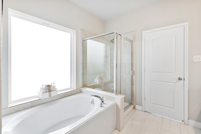 bathroom featuring tile patterned floors, a garden tub, and a shower stall