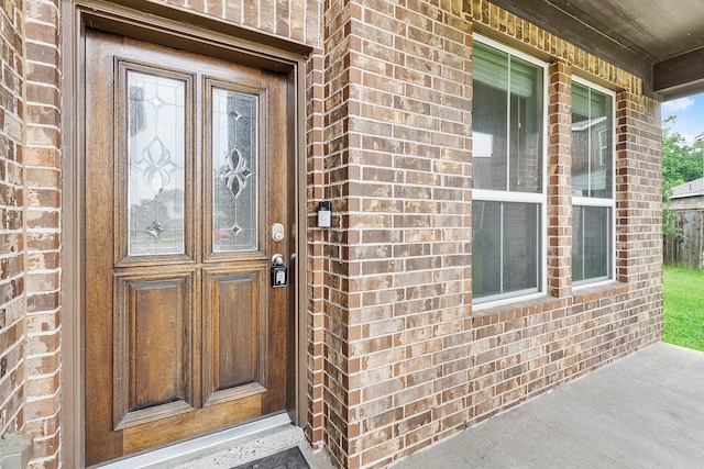 doorway to property featuring brick siding