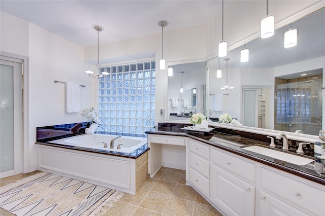 full bath with a garden tub, a stall shower, a chandelier, and vanity