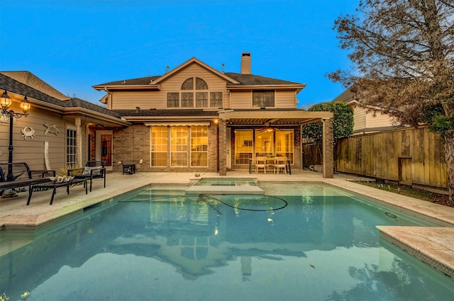 rear view of property featuring a fenced backyard, a chimney, a patio area, and brick siding