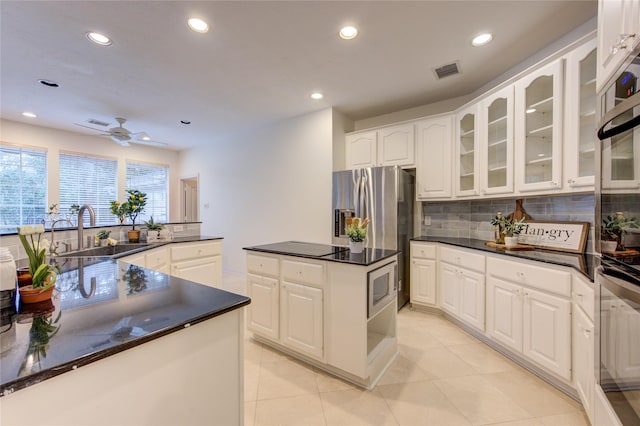kitchen with stainless steel fridge with ice dispenser, decorative backsplash, recessed lighting, and visible vents