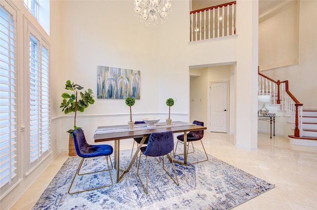 tiled home office with a high ceiling, a notable chandelier, and plenty of natural light