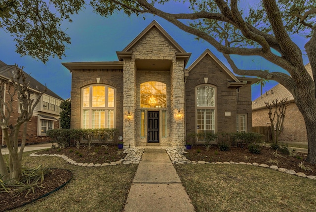 traditional-style home featuring brick siding and stone siding