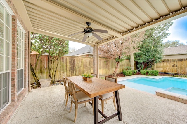 view of patio with a fenced in pool, a ceiling fan, a fenced backyard, and outdoor dining space