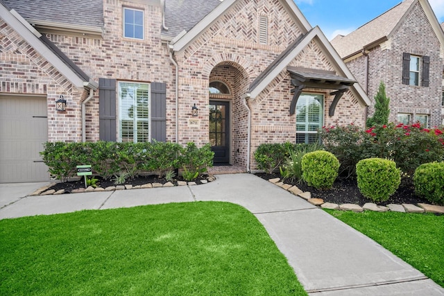 16711 Arboleda Dr, Humble, TX 77346 - view of front of house with brick siding, a front lawn, roof with shingles, and a garage