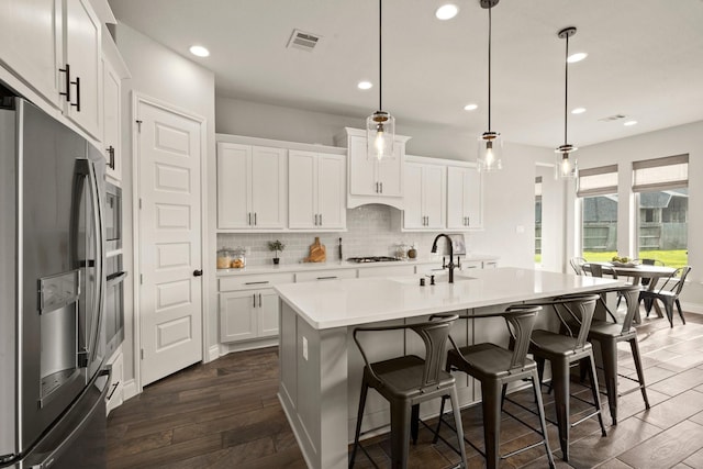 16711 Arboleda Dr, Humble, TX 77346 - kitchen with appliances with stainless steel finishes, a sink, tasteful backsplash, white cabinetry, and recessed lighting